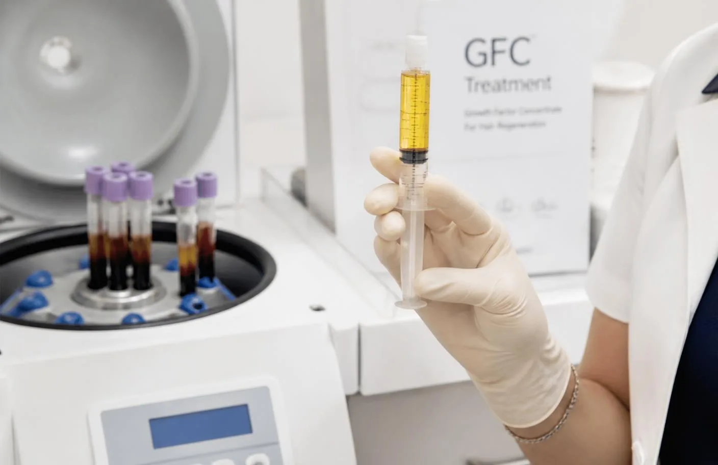 Growth factor concentrate serum prepared in a syringe beside a clinical centrifuge